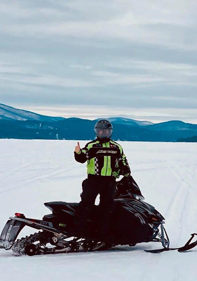 A person on a snowmobile in the snow.